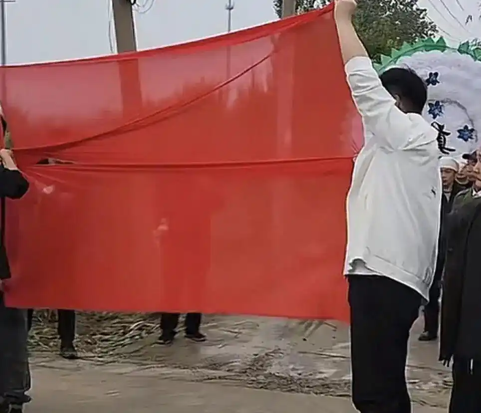 河南焦作婚车避让出殡队伍_红白事路口相逢红布相隔婚车先行_红让白习俗引发热议